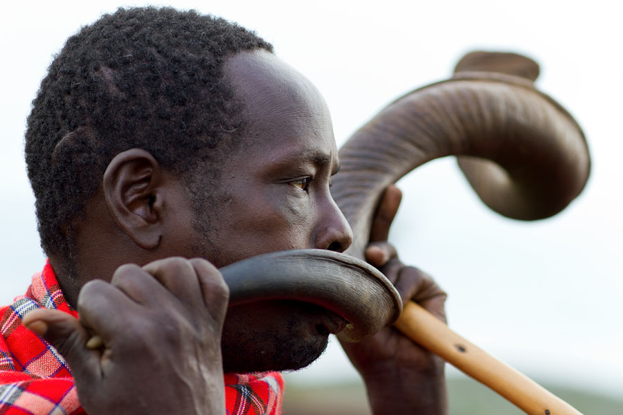  Masai blowing Kudu horn during ceremonial dance. Kenya